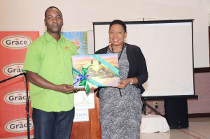 Janet Silvera John Lindo, chairman, MoBay Jerk Festival presents Minister Olivia 'Babsy' Grange with the gift of a Jamaican painting during the launch of the event. *** Local Caption *** Janet Silvera John Lindo, chairman, MoBay Jerk Festival presents Minister Olivia 'Babsy' Grange with the gift of a Jamaican painting during the launch of the event.